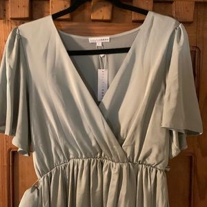 Two sage green bridesmaid dresses.